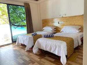 BodufolhudhooPaguro Seaview的酒店客房设有三张床和大窗户