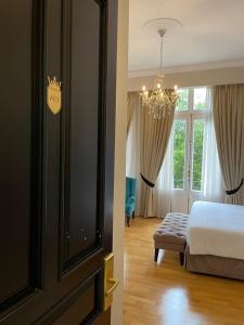 雅典雅典大厦豪华套房酒店的一间卧室配有一张床和一个吊灯