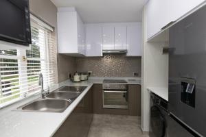 爱德华港Caribbean Estates - 35 Montego Bay by Luxe的厨房配有白色橱柜和水槽