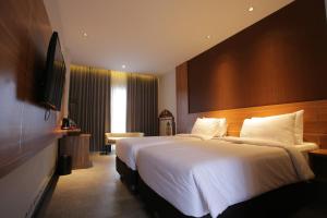 万隆Creative Restart Hotel - CARTEL Bandung的酒店客房设有一张大床和一台电视。