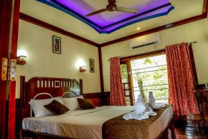 库玛拉孔Grand Villa Houseboat的一间卧室设有一张带天花板的床