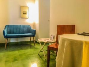 特鲁希略埃尔巴奇耶姆公寓的配有桌椅和蓝色椅子的房间