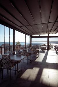 艾瓦勒克Carpe Diem Hotel的用餐室设有桌椅和窗户。