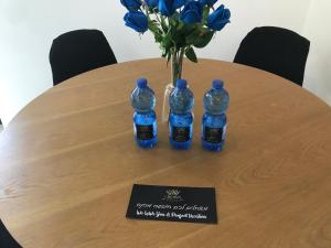 尼夫佐哈QUEEN of the dead sea by CROWN的一张桌子,上面有三瓶水和一瓶蓝玫瑰花