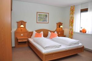 SchleidLandhotel Zur Pferdetränke的一间卧室配有两张带橙色枕头的床