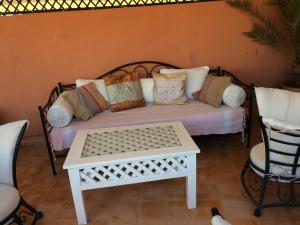 马拉喀什艾琳摩洛哥传统庭院旅馆的一张带枕头的床铺和一张桌子