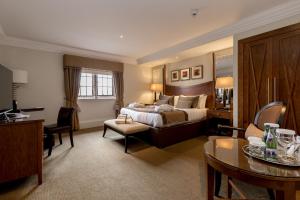 艾尔西部别墅酒店的酒店客房带一张床、一张桌子和椅子