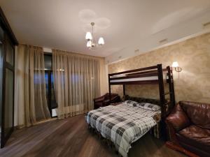 敖德萨阿卡迪亚公寓的一间卧室配有一张床、一把椅子和一张沙发