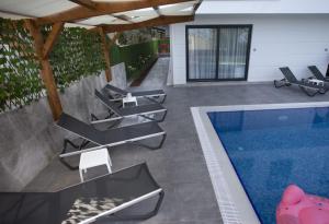 AltınkumYILDIZ PREMIUM APART 1的房屋旁设有带游泳池和椅子的庭院。