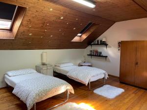 洛索内Casa Madonnina的配有木天花板的客房设有两张床。