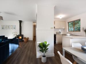 赫本温泉Springview Cottage的厨房以及带白色橱柜和桌子的客厅。