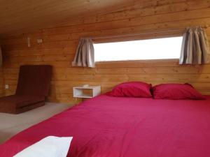 尼姆Le Petit Chalet de Nîmes Shantay Youstay的卧室设有红色大床和窗户。