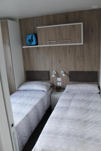 伊斯普拉Dkamping Village - International Camping Ispra的小客房内的两张床,配有两张sidx sidx单人床
