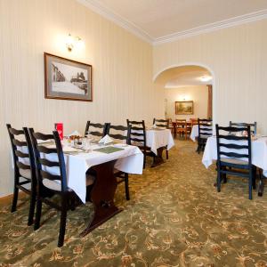 威克尼特克里夫酒店的一间设有白色桌椅的用餐室