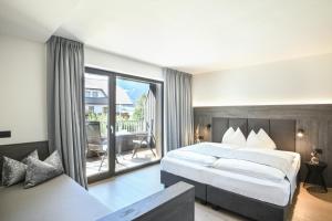 瓦尔道拉凯利阿尔平酒店的一间带大床的卧室和一个阳台