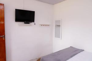 费尔南多 - 迪诺罗尼亚CASA PITANGA的一间卧室配有一张床,墙上配有电视