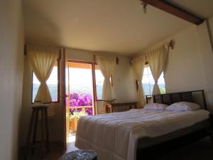 瓦拉斯Schatzi Lodge的一间卧室设有一张床和一个大窗户