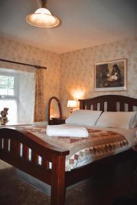 阿马Basil Sheils B&B Accommodation Armagh的一间卧室设有一张大型木床和一个窗户。