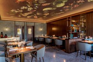 威尼斯Ca'di Dio-Small Luxury Hotel的餐厅设有酒吧,配有桌椅