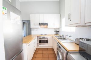 普利登堡湾Goose Valley Golf Estate Unit J6的厨房配有白色橱柜和炉灶烤箱。