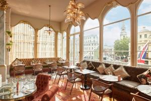 伦敦The Clermont London, Charing Cross的餐厅设有桌椅和大窗户。