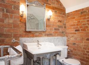斯托尔河畔希普斯顿老科林客舍的一间带白色水槽和砖墙的浴室