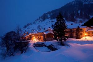 圣尼古拉斯瓦尼耶餐饮酒店的夜晚雪中的房子