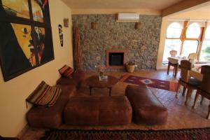 奥伊俄贞非洲古堡酒店的客厅配有真皮沙发和桌子