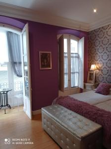 桑托尼亚阿罗亚眠托布西罗旅馆的一间卧室设有紫色的墙壁和一张沙发