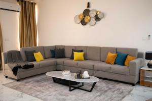 莱基Kay's Comfort Place的客厅配有带黄色和蓝色枕头的灰色沙发
