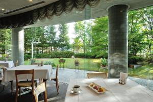 一关贝里诺一关酒店的餐厅设有白色的桌椅和大窗户