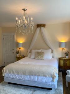 Saint MartinsBeach Street Inn的卧室配有一张带吊灯的大型白色床。