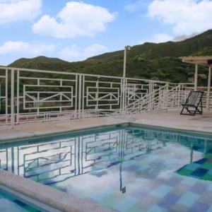 塔甘加Hostel Green Light的一个带围栏和椅子的游泳池