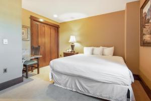 帕克城Arrowleaf Lodge - 1 Bed Studio #101A的酒店客房设有一张大床和一张书桌。