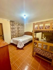皮斯科Hospedaje Anais的一间卧室设有两张双层床,铺有木地板。