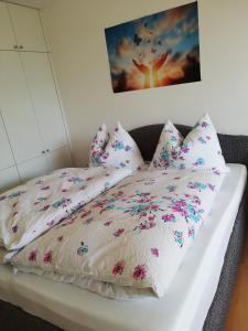 巴德哥依斯恩Lebensfreude Appartement的一张床上有白色床单和粉红色的鲜花