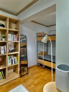 江陵市Saesori Guesthouse的带两张双层床和书架的客房
