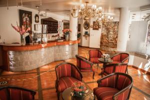 普诺Hotel Hacienda Puno Centro Histórico的一间酒吧,配有红色的桌椅和柜台