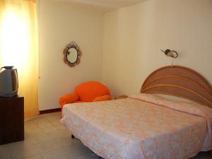 雷焦卡拉布里亚B&B La Pineta的一间卧室配有一张床、一把椅子和镜子