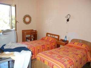 雷焦卡拉布里亚B&B La Pineta的客房设有两张床、一张桌子和一扇窗户。