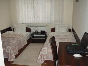 罗兹Luksusowe Apartamenty Łódź的一间卧室配有两张床和一张带笔记本电脑的书桌