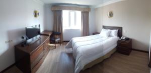昆卡Hotel El Conquistador的酒店客房设有一张大床和一台电视。