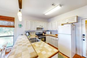 彭萨科拉Molokai Villas 7B的厨房配有白色橱柜和白色冰箱。