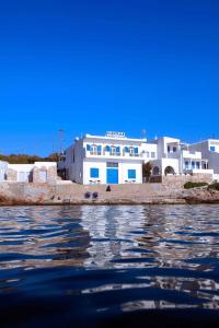 锡基诺斯岛Maistrali的白色的建筑,有蓝色的窗户,靠近水面
