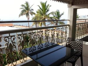 蓬蒂切里莲花湾景酒店的阳台配有桌子,享有海滩美景