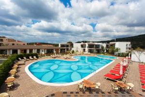 贝拉姆卡尔Assos Barbarossa Special Class Hotel的一个带躺椅的游泳池,一个度假村