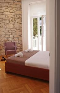 茨里克韦尼察Guest House Villa Dagmar的一间卧室配有一张床、一把椅子和石墙