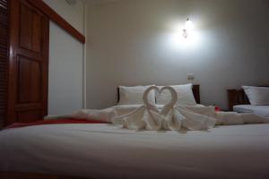 清迈Romsak Lanna Resort Chiang Mai的一张由枕头制成的白色心床