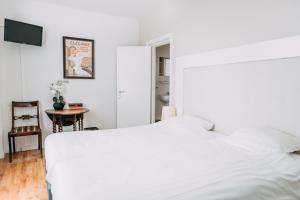 阿姆斯特尔芬阿比纳咖啡餐厅酒店的卧室配有白色的床和桌子