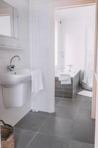 阿姆斯特尔芬阿比纳咖啡餐厅酒店的白色的浴室设有水槽和浴缸。